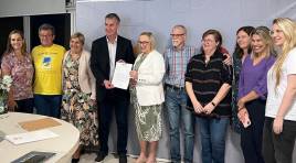 #DescriçãodaImagem: Reunião na SES. Aparecem na imagem: Fernanda Mielke, coordenadora do Programa TEAcolhe, Vicente Fiorentini, secretária adjunta Ana Costa, deputado Eduardo Loureiro, eles seguram documento que propõe criação do Monitor Escola