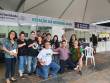 Representantes, funcionários envolvidos na ação da 65º Feira do Livro de Porto Alegre e outras autoridades. Estão posicionadas em duas fileiras, sendo a primeira ajoelhados e a segunda em pé. 