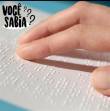 #DescriçãodaImagem card formato quadra com tons de azul nas laterais, na parte central em branco aparece representação tátil de símbolos braille com dedos fazendo a leitura. no canto superior da imagem o texto: Você sabia?